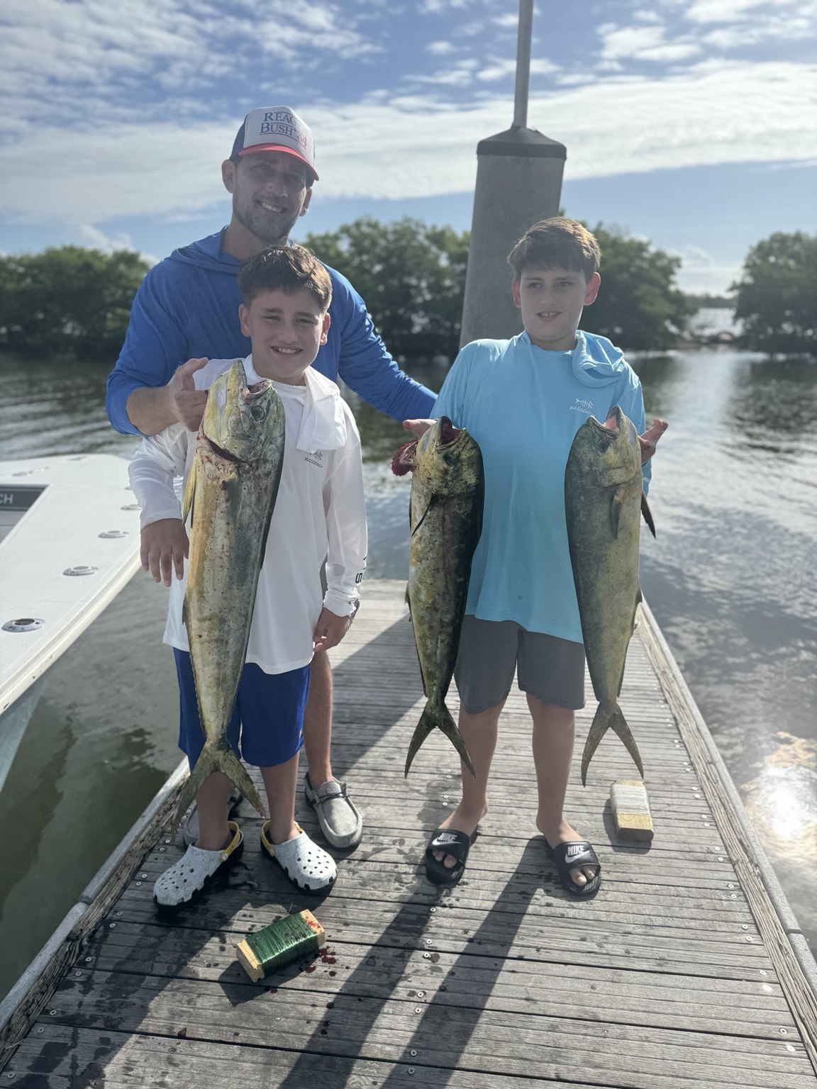 Two children holding mahi after fishing with Get Busy Fishing Charters in Boynton Beach